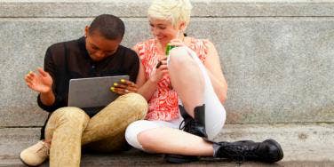 two people sitting laughing on computer