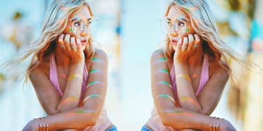 Woman sitting outside with hand on face 