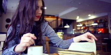 woman at coffee shop reading book