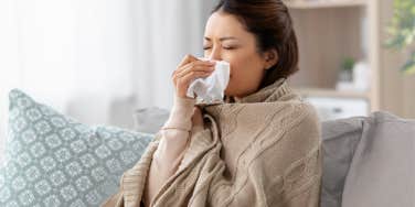 Sick employee sitting at home on the couch. 