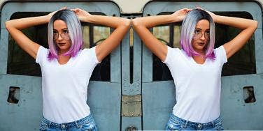 young woman with colorful hair in front of a train, pondering chaotic relationships