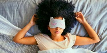 woman lying in bed with eye mask