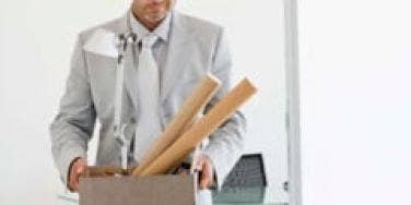 man-in-suit-carries-office-supplies