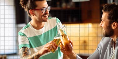 Men tapping a beer, laughing