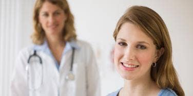 smiling woman with doctor in the background