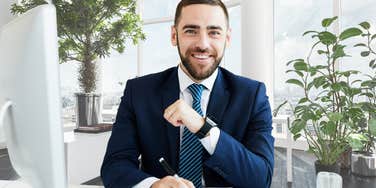 CEO smiling while sitting in his office. 