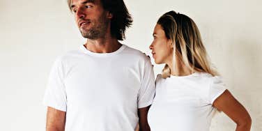 man and woman against a white background, looking away from each other
