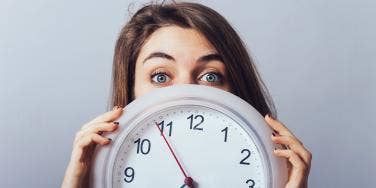 woman holding up clock