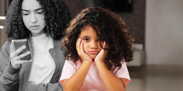 sad young girl in front of teen scrolling phone