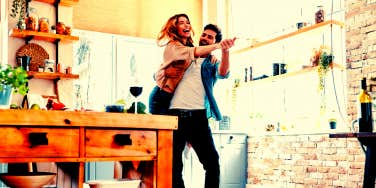 man and woman cooking and dancing in the kitchen