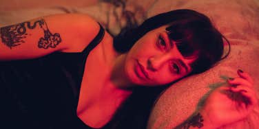 girl laying in bed with red light shining