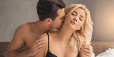 man kissing woman on neck