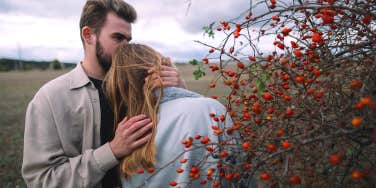 man kissing woman