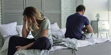 couple upset on opposite sides of bed