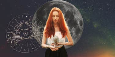 woman holding crystals for cancer zodiac sign in front of moon