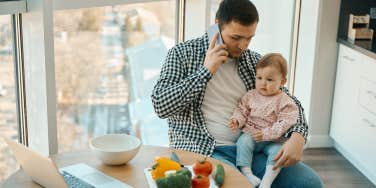 man on the phone holding a babe