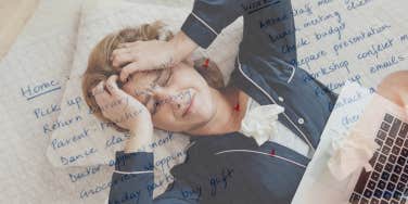 Woman stressed and sick, laying on floor while her to-do list dances in her head