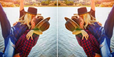 couple wearing plaid and hats kissing by the water