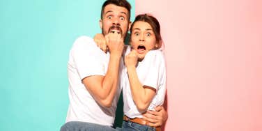 man standing in front of blue and woman standing in front of pink