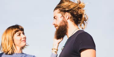 young woman touching her husband's beard outdoors