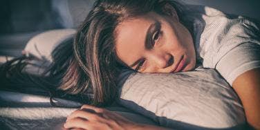 woman lying on bed looking sad
