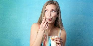 woman eating ice cream in front of blue background