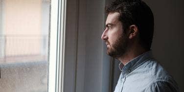 sad man looking out window