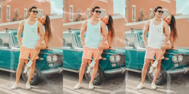 Couple hanging out by old care outside smiling