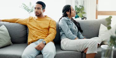 unhappy couple sitting on couch at home