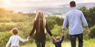 family walking together outside in a field