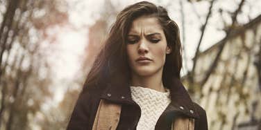 long-haired brunette woman looking upset in the woods, sepia-toned