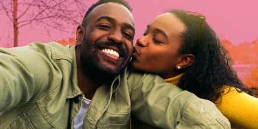 woman kissing man's cheek while taking selfie