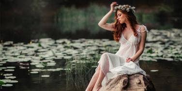 woman sitting by lilypads