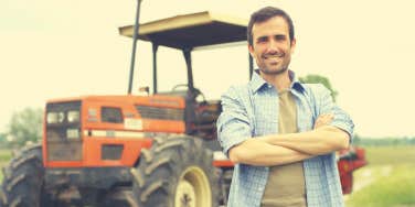 farmer standing in front of his tractor smiling