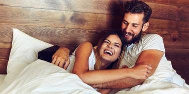 man and woman cuddling in bed