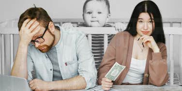 couple going over finances, baby looming in background