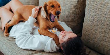 woman lying on couch with dog