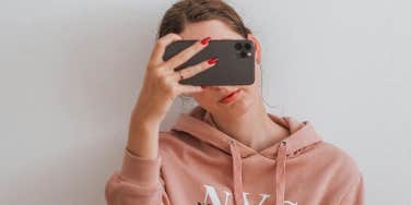 woman taking a mirror selfie with iphone