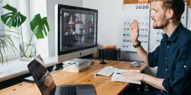 man having Zoom video conferencing call via computer while sitting at desk