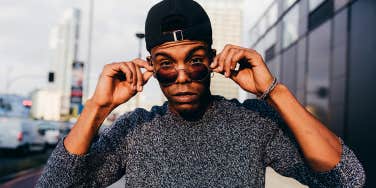 man wearing sunglasses and backwards hat