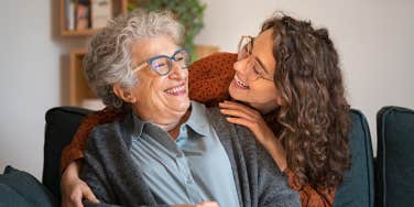 grandmother and granddaughter hugging at home and looking at each other.