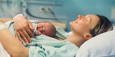 Woman post birth with baby on chest 