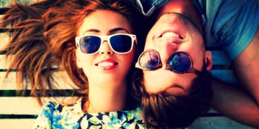 Guy and girl in sunglasses laying down