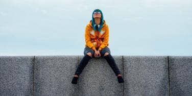 woman on ledge with phone