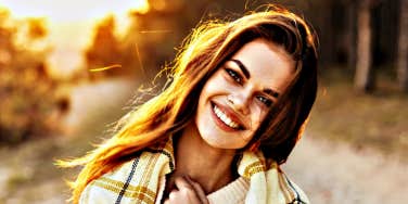 Glowing happy young woman on country road 