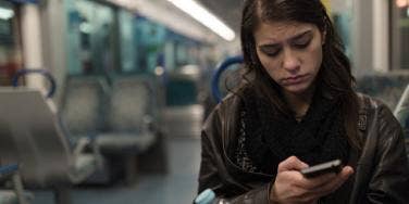 unhappy woman looking at memes on phone