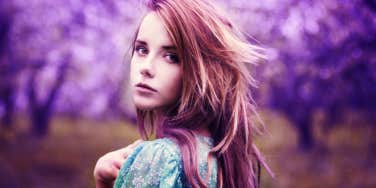 young redhead woman in a field of purple trees