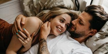 man and woman cuddling in bed