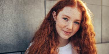 woman with red hair smiling at camera