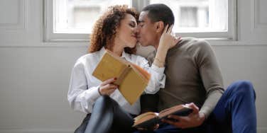 couple kissing over a book